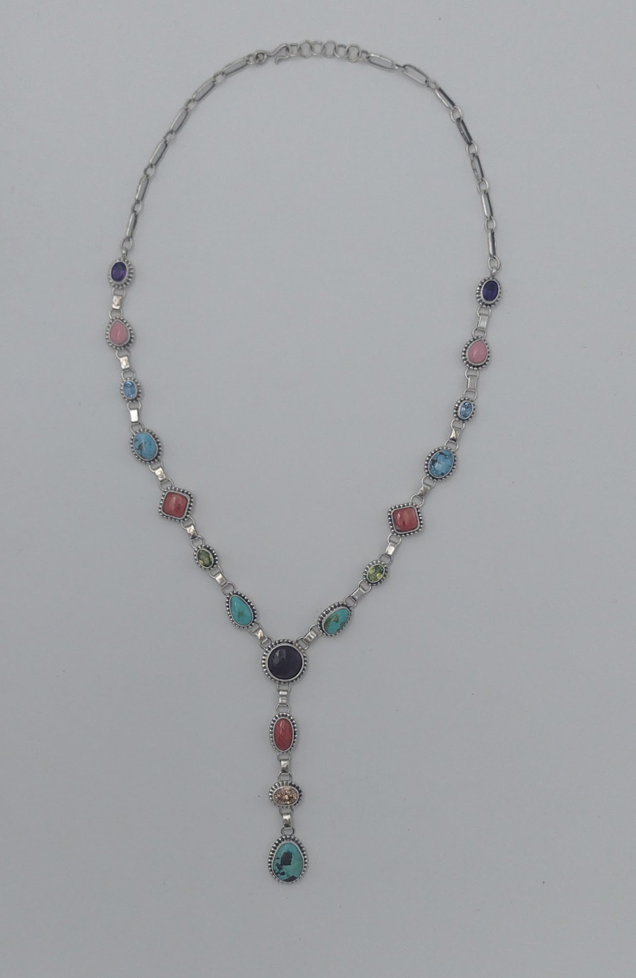Necklace with multicolored gemstones on a gray background